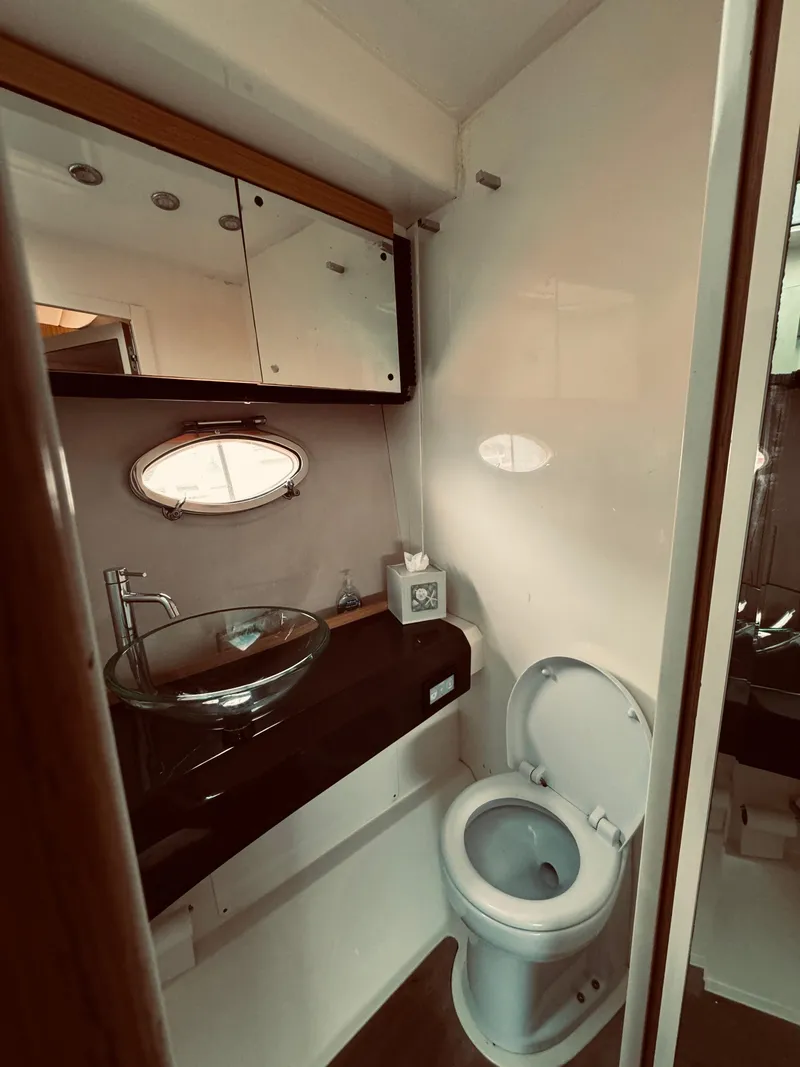 Slide: The Image of 2009 Azimut Atlantis 50 yacht bathroom with modern fixtures and porthole window. - 22