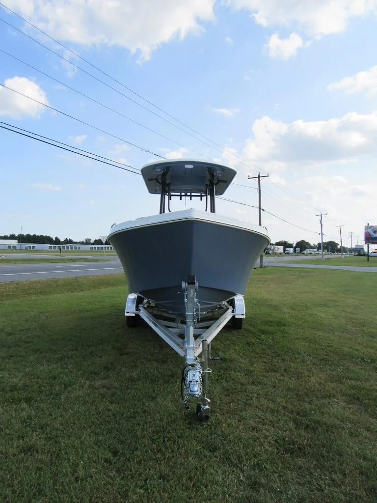 Slide: The Image of 2025 Parker 23 SE CC boat on trailer, parked on grass under blue sky. - 4
