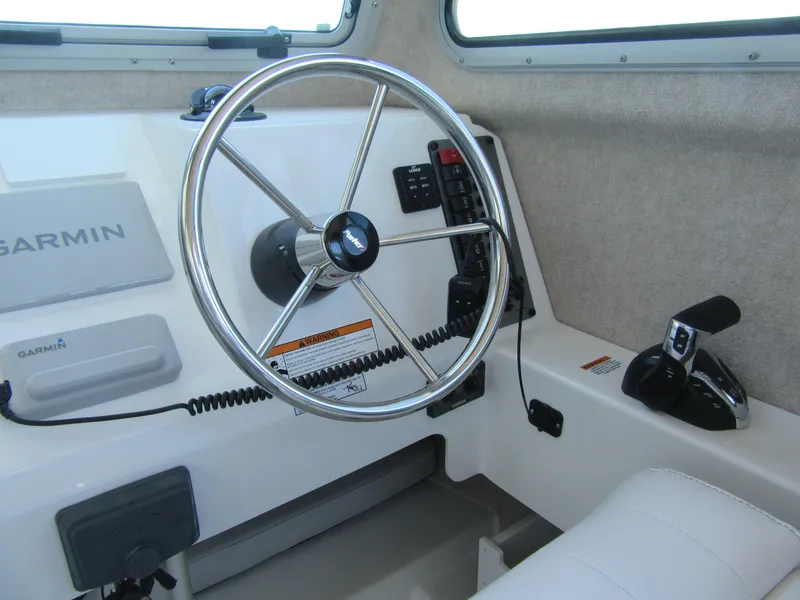 Slide: The Image of Steering wheel and controls of 2025 Parker 2120 Sport Cabin boat interior. - 10