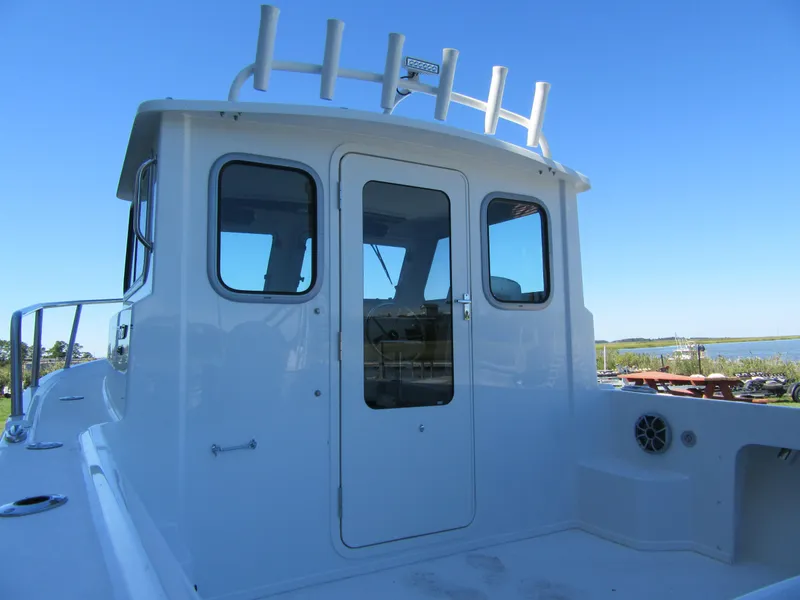 Slide: The Image of 2025 Parker 2120 Sport Cabin boat with sleek white exterior and clear blue sky backdrop. - 4