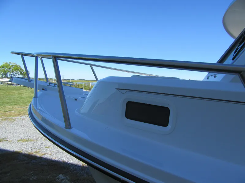 Slide: The Image of 2025 Parker 2120 Sport Cabin boat, side view with railing, under clear blue sky. - 5