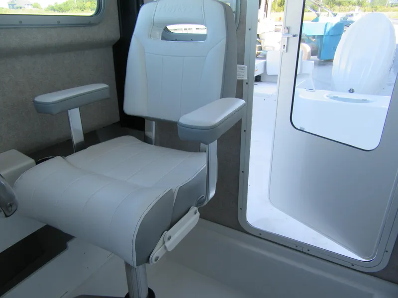 Slide: The Image of 2025 Parker 2120 Sport Cabin interior with white captain's chair and open cabin door. - 9
