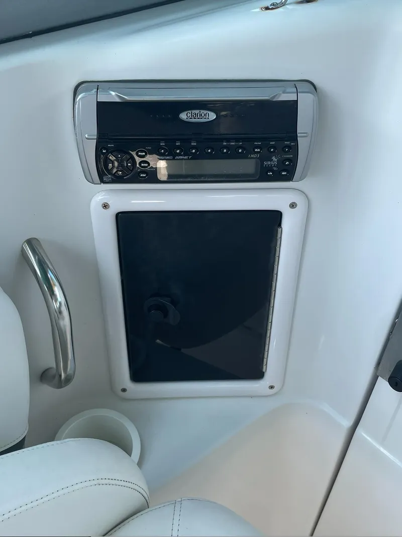 Slide: The Image of 2004 Four Winns 250 Horizon boat interior with stereo system and storage compartment. - 17