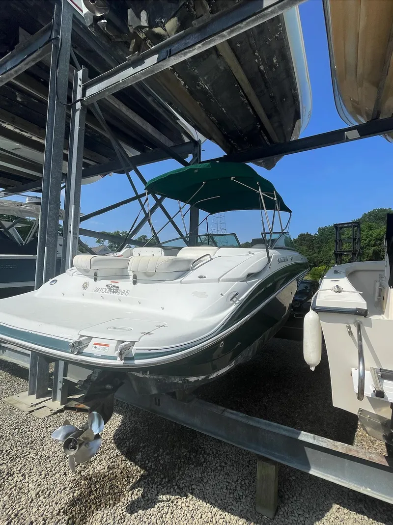Slide: The Image of 2004 Four Winns 250 Horizon boat in dry storage with green canopy. - 4