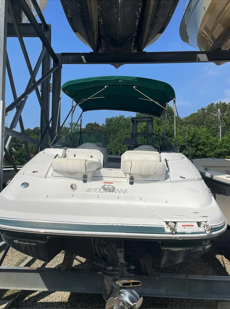Slide: The Image of 2004 Four Winns 250 Horizon boat with green canopy in storage. - 5