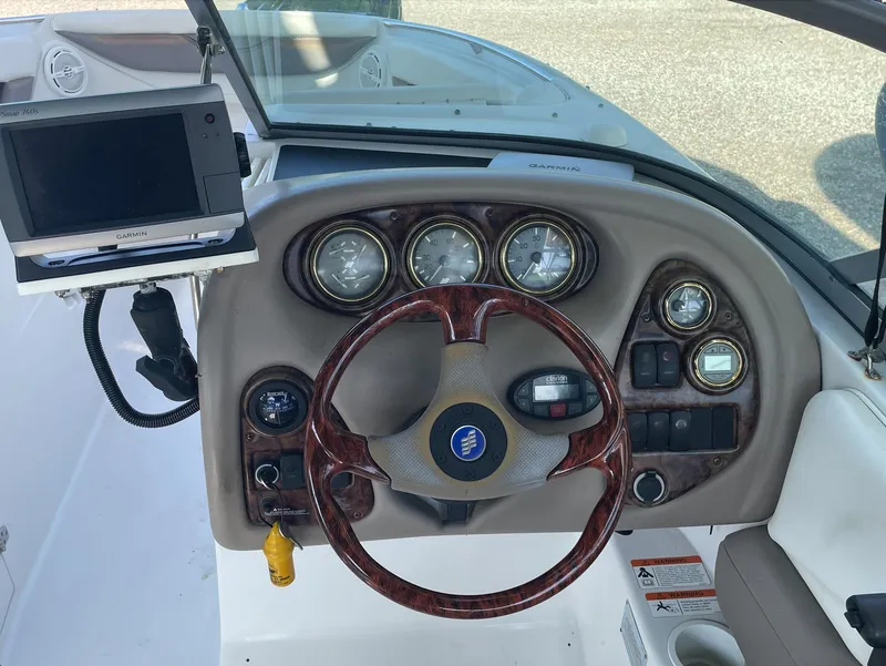 Slide: The Image of 2004 Four Winns 250 Horizon boat dashboard with steering wheel and navigation system. - 6