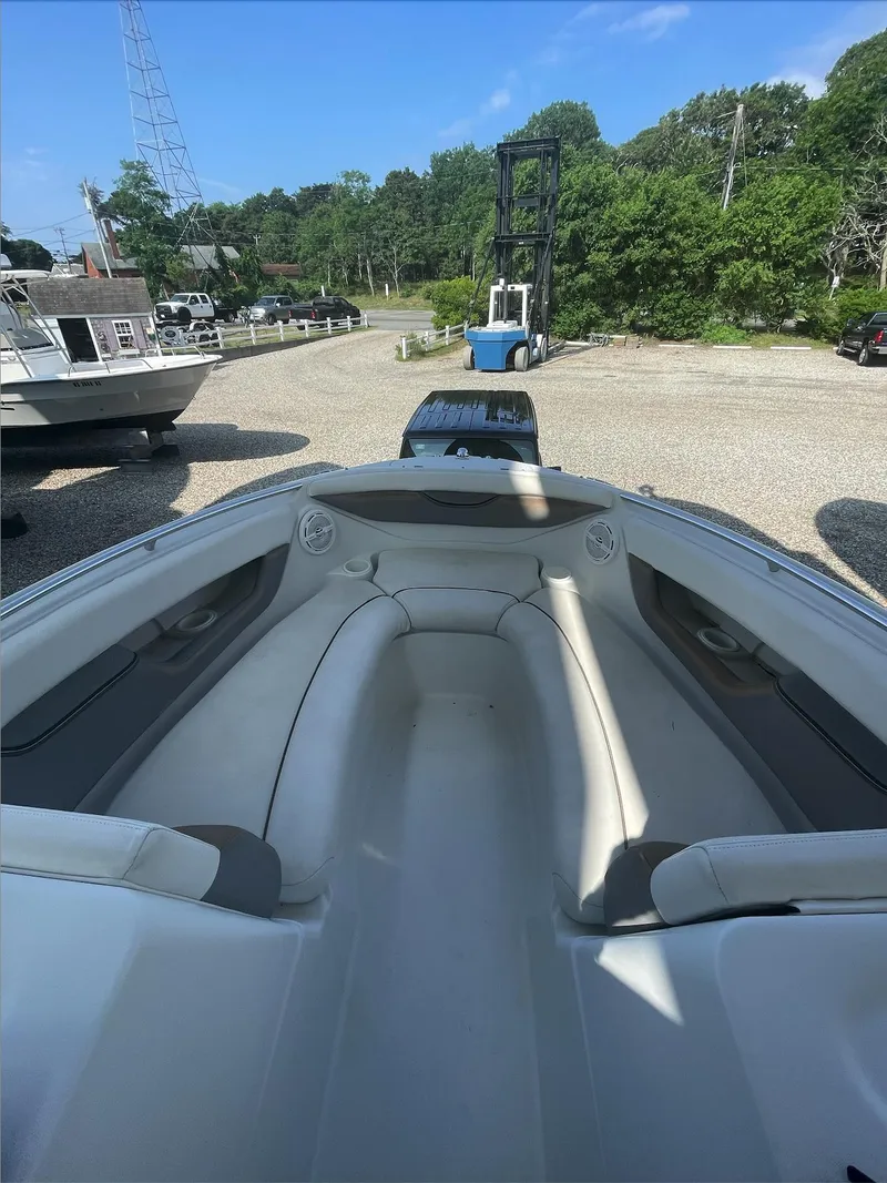 Slide: The Image of 2004 Four Winns 250 Horizon boat interior with white seating, parked outdoors. - 8