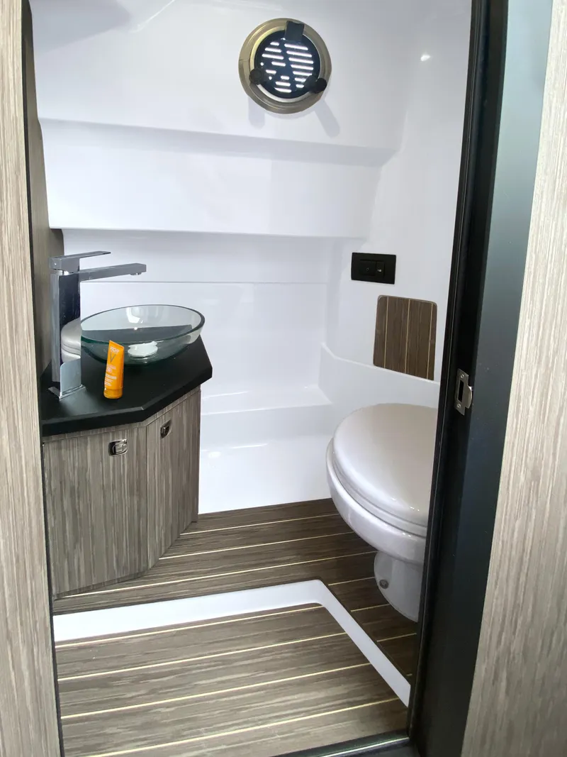 Slide: The Image of 2025 Ranieri CAYMAN 28 EXECUTIVE boat bathroom with modern fixtures and wood accents. - 28