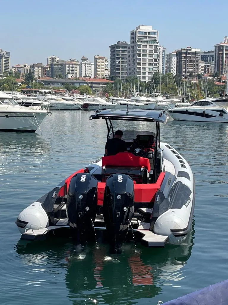 Slide: The Image of 2025 Ranieri CAYMAN 28 EXECUTIVE boat docked in a marina with cityscape background. - 6