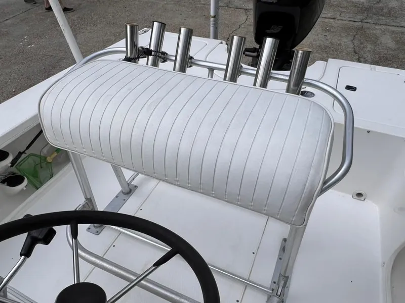 Slide: The Image of 2001 Rinalli 2100 Bay boat console with white cushioned seat and rod holders. - 13