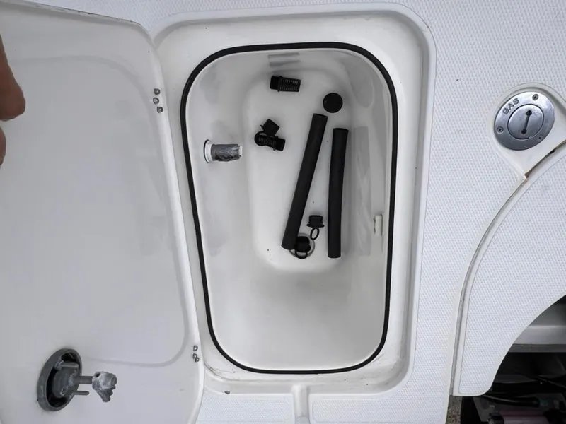 Slide: The Image of Open storage compartment of 2001 Rinalli 2100 Bay boat with various accessories inside. - 14