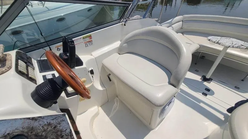 Slide: The Image of 1996 Doral 300 SC boat interior with white seating and wooden steering wheel. - 15