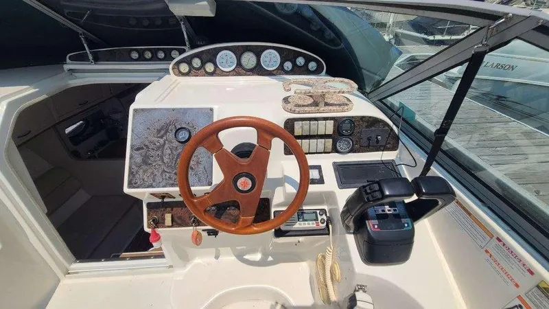 Slide: The Image of 1996 Doral 300 SC boat dashboard with wooden steering wheel and control panel. - 16