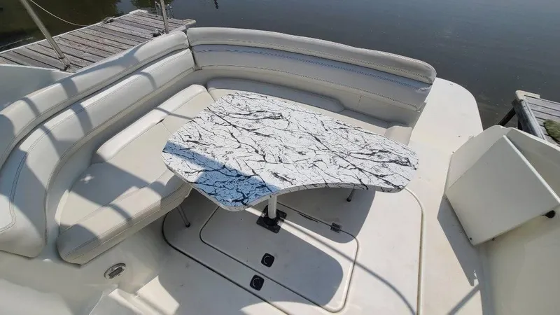 Slide: The Image of 1996 Doral 300 SC boat interior with marble-patterned table and cushioned seating. - 17
