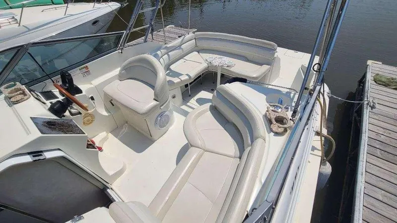 Slide: The Image of 1996 Doral 300 SC boat interior with white seating and helm, docked by the water. - 18