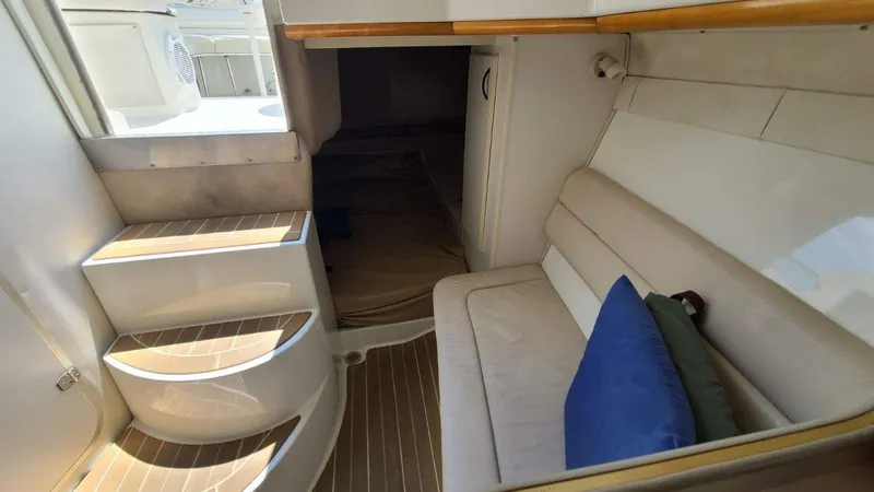 Slide: The Image of Interior of 1996 Doral 300 SC boat with seating and steps, featuring a cozy cabin area. - 4