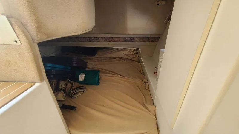 Slide: The Image of 1996 Doral 300 SC cabin interior with beige bedding and stored items. - 8