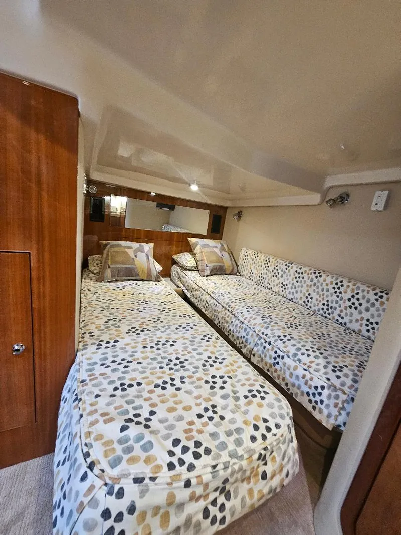 Slide: The Image of 2007 Regal Commodore 4460 cabin with twin beds and patterned bedding. - 15