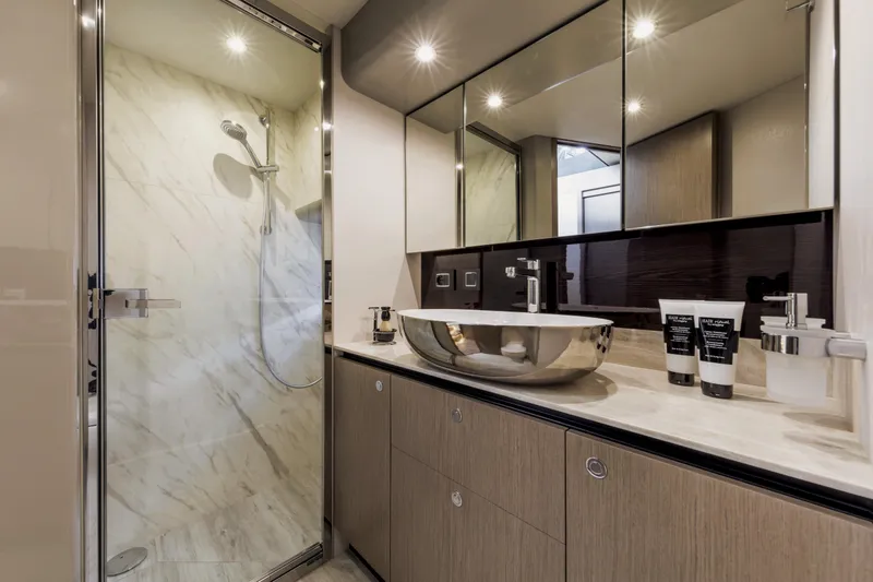 Slide: The Image of Luxurious bathroom in the 2025 Absolute 48 Navetta yacht with modern fixtures and marble shower. - 14
