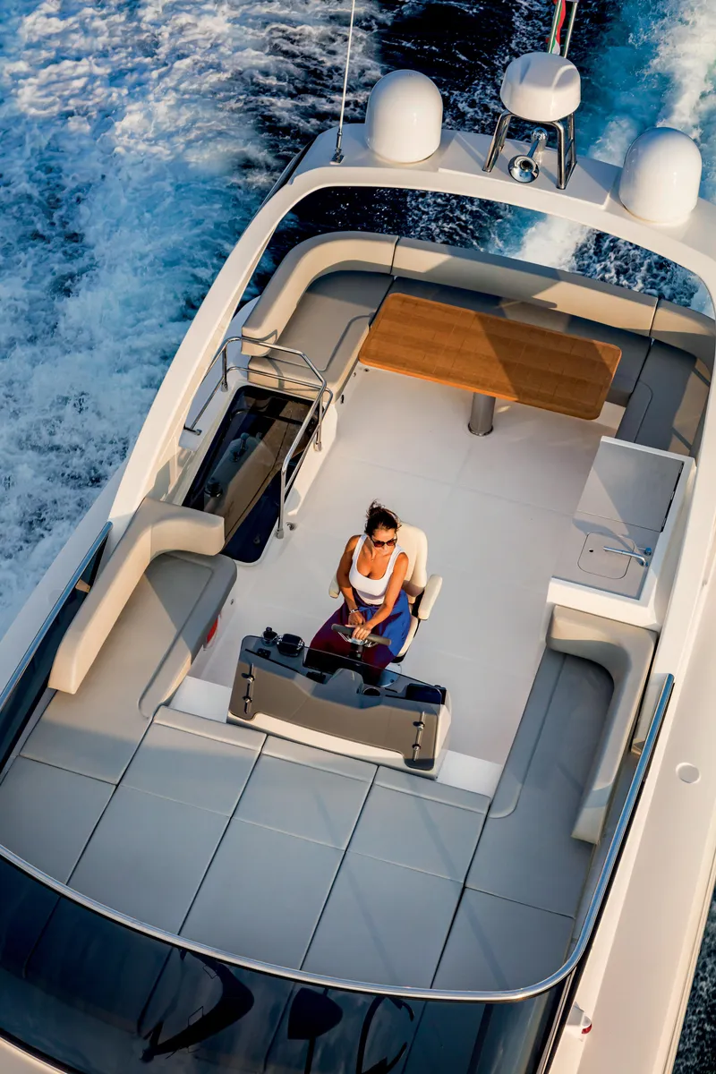 Slide: The Image of 2025 Absolute 48 Navetta luxury yacht cruising with a person at the helm. - 4