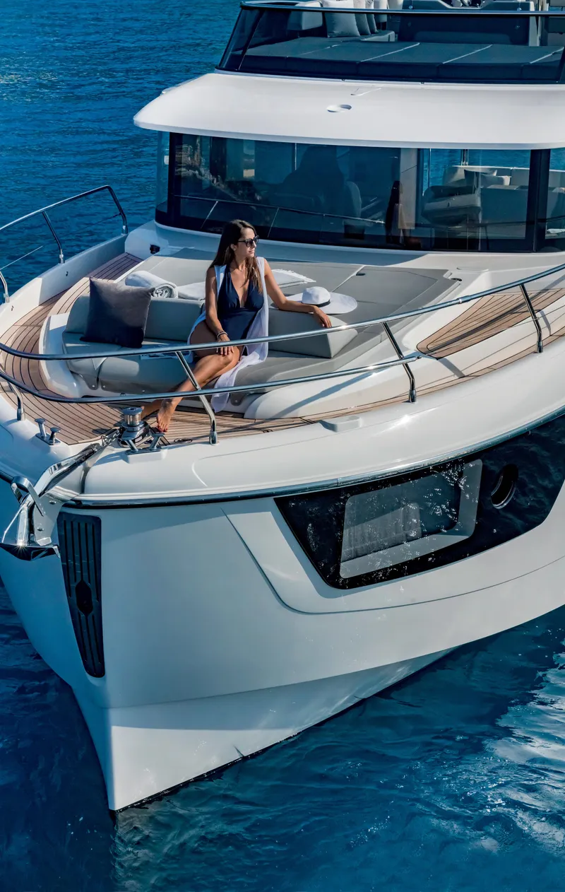 Slide: The Image of 2025 Absolute 48 Navetta yacht with a woman relaxing on the deck. - 7