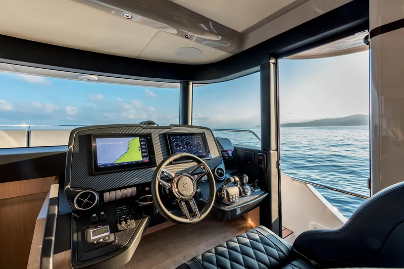 Slide: The Image of 2025 Absolute 48 Navetta yacht helm with advanced navigation systems and ocean view. - 9