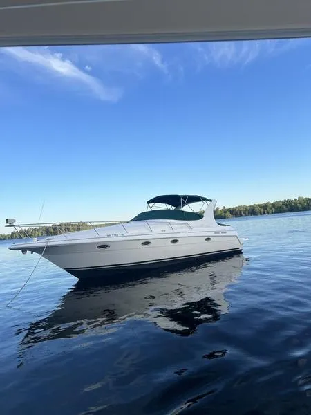 Slide: The Image of 1999 Cruisers Yachts 3375 Esprit on calm lake under clear blue sky. - 1