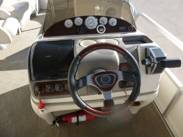 Slide: The Image of 2005 Sun Tracker Party Barge 27 I/O helm with steering wheel and control panel. - 10