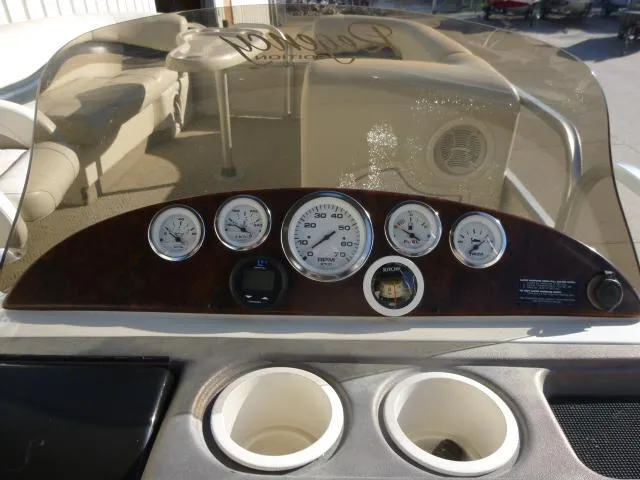 Slide: The Image of 2005 Sun Tracker Party Barge 27 I/O dashboard with gauges and cup holders. - 13