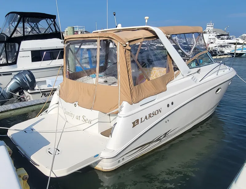 The Image of 2000 Larson Cabrio 290 boat docked in marina with tan canopy. - 0