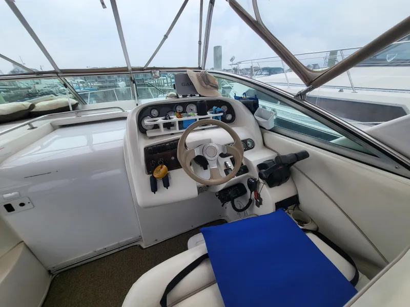 Slide: The Image of Cockpit of 2000 Larson Cabrio 290 boat with steering wheel and control panel. - 12