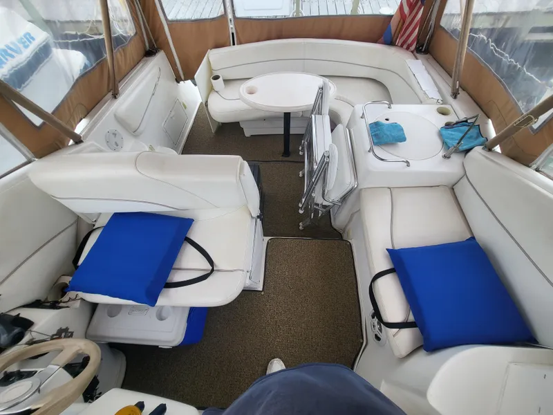 Slide: The Image of 2000 Larson Cabrio 290 boat interior with white seating and blue cushions. - 14