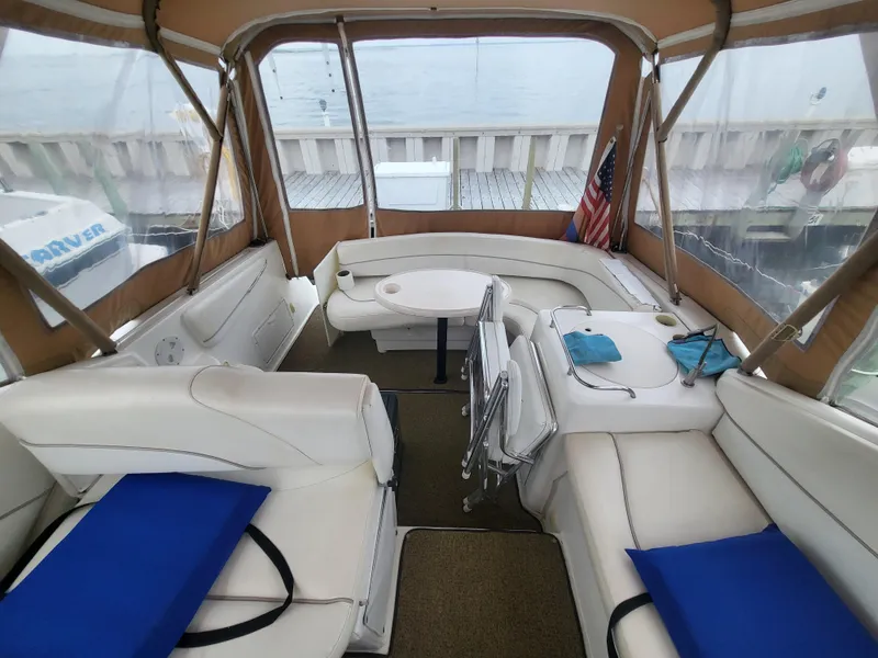 Slide: The Image of Interior of 2000 Larson Cabrio 290 boat with white seating and American flag. - 15
