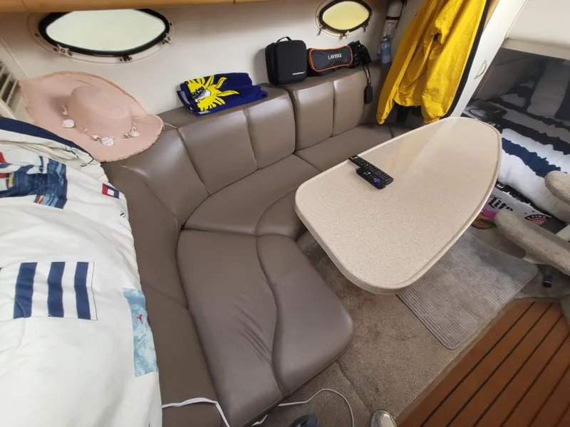 Slide: The Image of Interior of 2000 Larson Cabrio 290 boat with beige seating and table. - 16