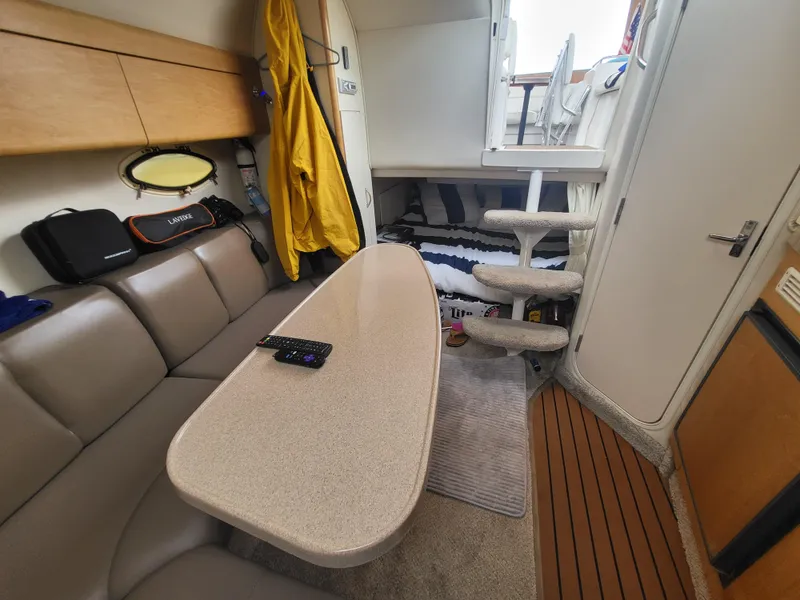 Slide: The Image of Interior of 2000 Larson Cabrio 290 boat with seating, table, and stairs. - 17