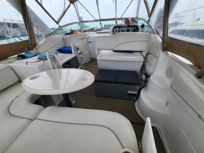 Slide: The Image of 2000 Larson Cabrio 290 boat interior with seating, table, and helm. - 18