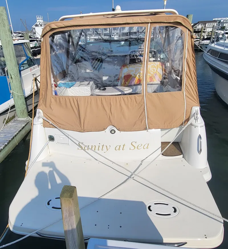 Slide: The Image of 2000 Larson Cabrio 290 boat named "Sanity at Sea" docked at a marina. - 21