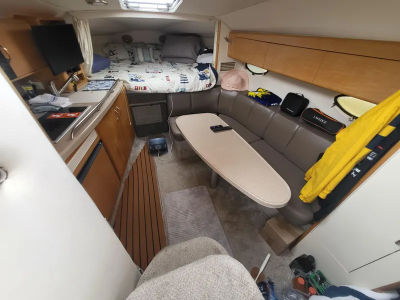 Slide: The Image of Interior of 2000 Larson Cabrio 290 boat with seating, table, and sleeping area. - 4