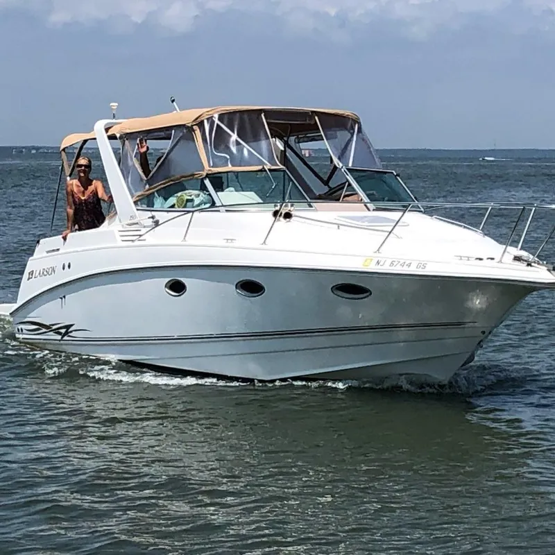Slide: The Image of 2000 Larson Cabrio 290 boat cruising on open water under clear skies. - 5
