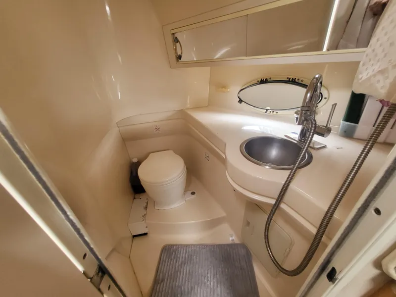 Slide: The Image of 2000 Larson Cabrio 290 boat bathroom with sink, toilet, and mirror. - 6