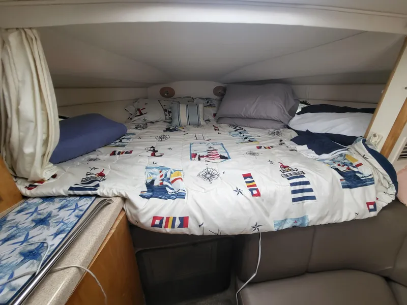 Slide: The Image of Cozy cabin bed in 2000 Larson Cabrio 290 boat with nautical-themed bedding. - 8