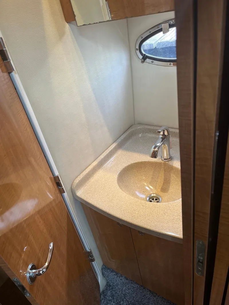 Slide: The Image of 2003 Regal Commodore 3860 bathroom sink with wooden cabinetry and porthole window. - 23
