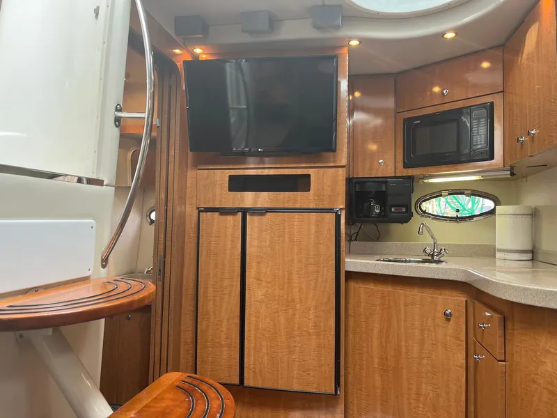 Slide: The Image of Interior of 2003 Regal Commodore 3860 yacht with kitchen, TV, and wooden cabinetry. - 26