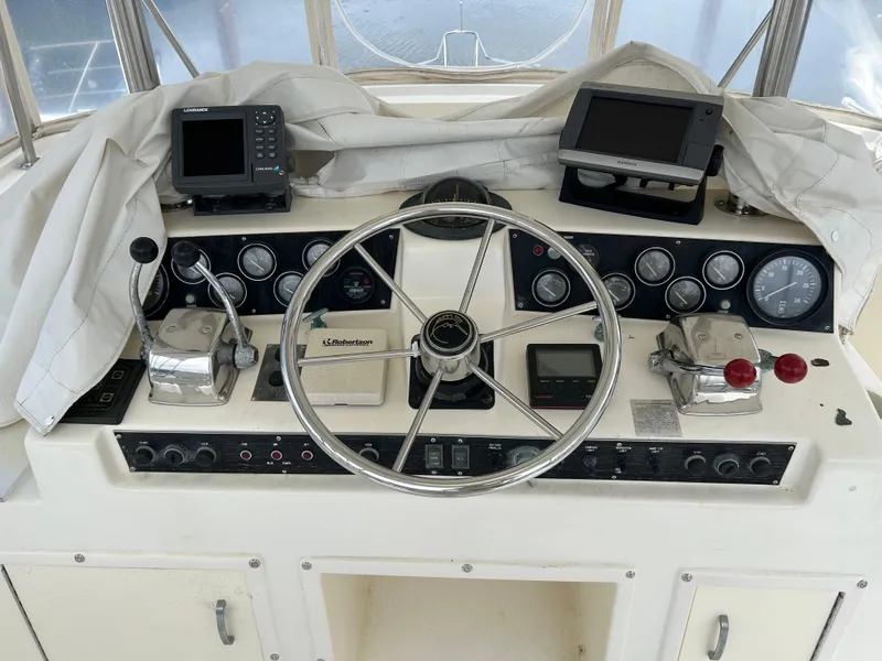 Slide: The Image of 1990 Egg Harbor 42 Golden Egg helm with steering wheel, gauges, and navigation equipment. - 23
