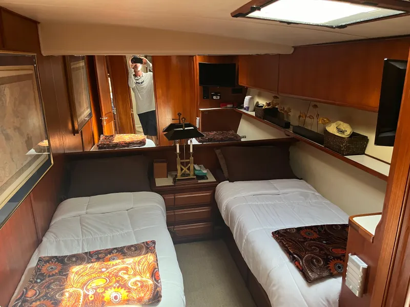 Slide: The Image of 1989 Viking 57 Convertible yacht cabin with twin beds and wooden interior. - 8