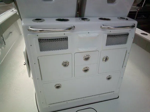 Slide: The Image of 2024 Sportsman 267OE boat console with storage compartments and rod holders. - 16