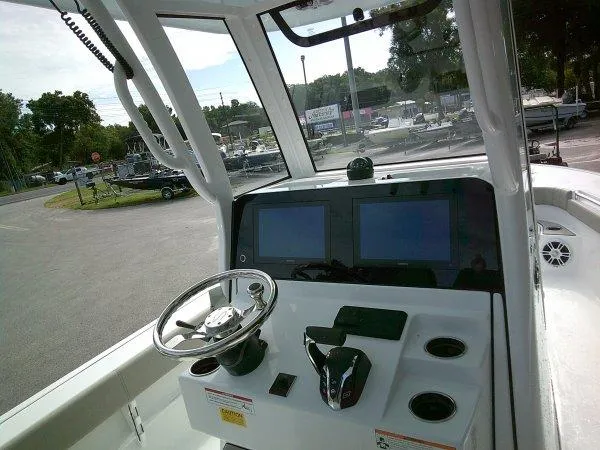 Slide: The Image of 2024 Sportsman 267OE boat cockpit with dual screens and steering wheel. - 6