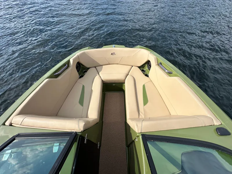 Slide: The Image of 2023 MasterCraft NXT 22 boat with beige seating on water. - 11