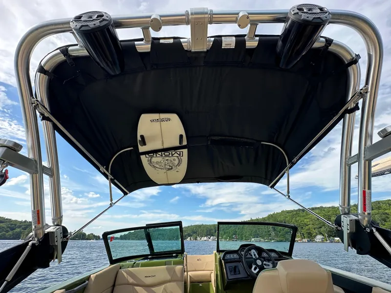 Slide: The Image of 2023 MasterCraft NXT 22 boat interior with wakeboard tower on a lake. - 12