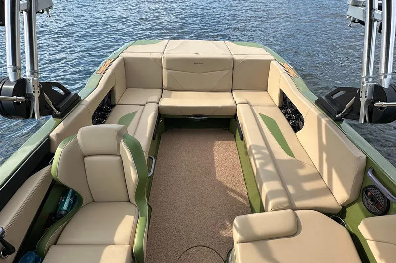 Slide: The Image of 2023 MasterCraft NXT 22 boat interior with beige and green seating on the water. - 19